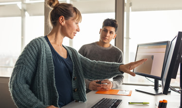 Zwei Personen im Gespräch am Arbeitsplatz